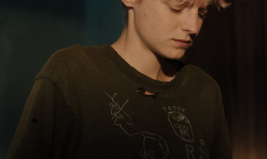 Distressed Graphic Tee with Abstract Faces Design Worn by  Emma Corrin as Darby Hart