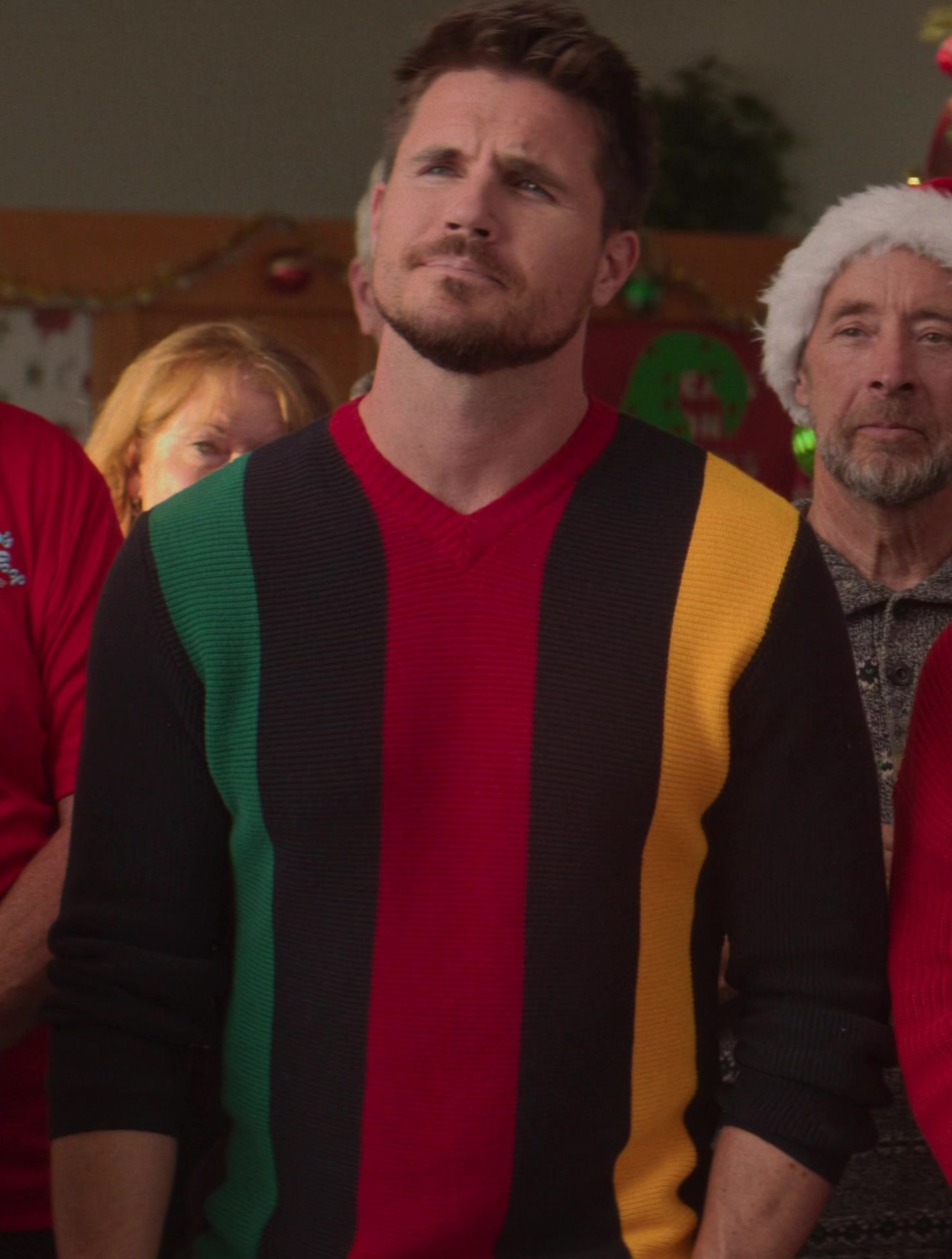 Worn on EXmas (2023) Movie - Bold Color Block Sweater in Red, Green, Yellow, and Black Worn by Robbie Amell as Graham Stroop