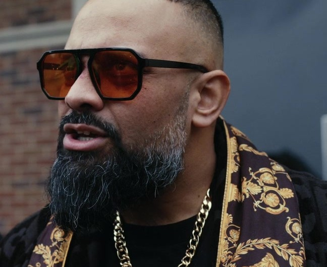 Bold Square Frame Sunglasses with Amber Tinted Lenses and Black Acetate Frame Worn by Guz Khan as Chucky